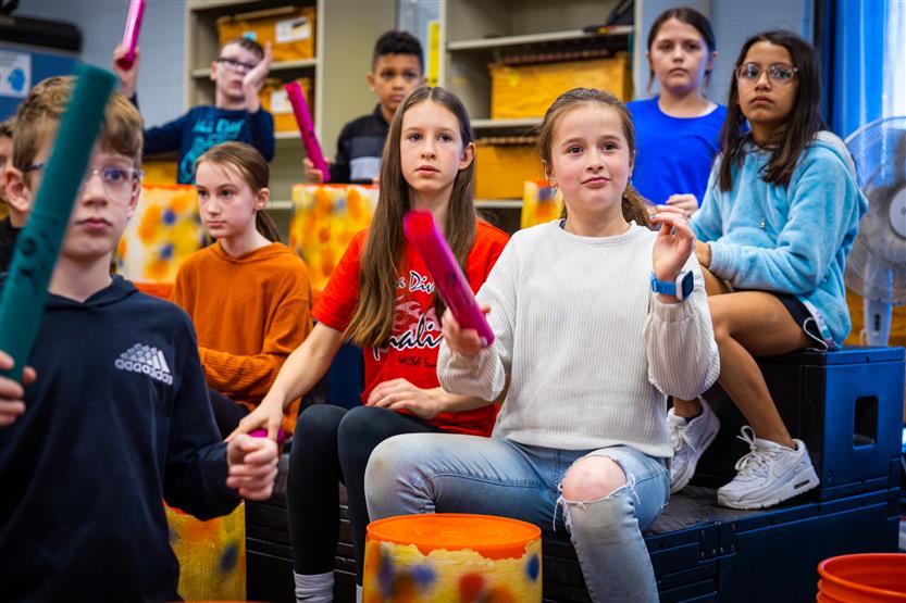 Students play drums in music class